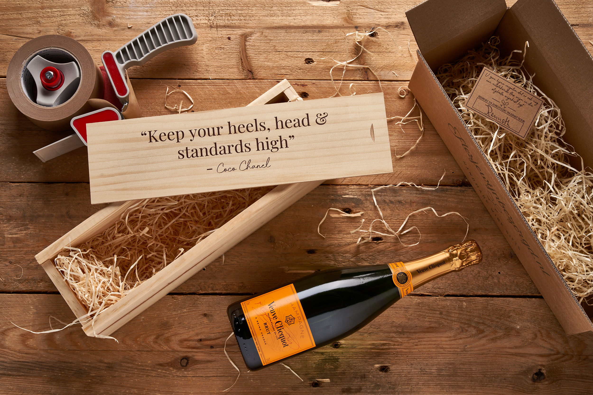 Enkele wijnkist met bedrukking en fles Veuve Clicquot Brut Champagne op tafel