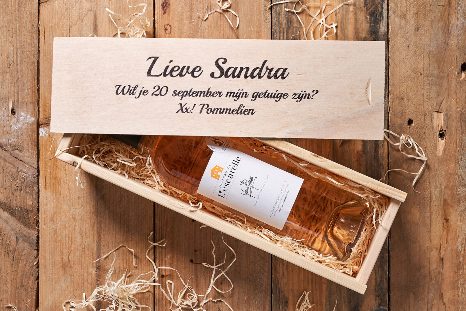 Houten kistje met fles wijn met rosé wijn en bedrukte wijnkist van bovenaf